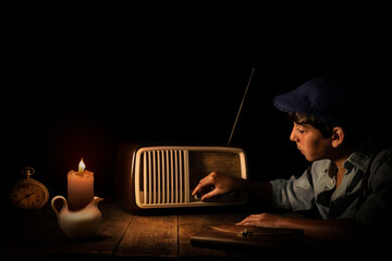 boy listens retro radio, in the dark with candle light, horizontal, 30s, 40s, nostalgic moody, - 454618916