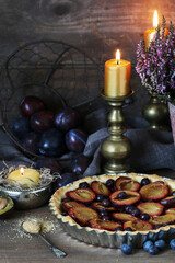 Traditional round plum pie on the table.
