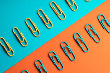 Blue and orange paper clips in rows opposite each other