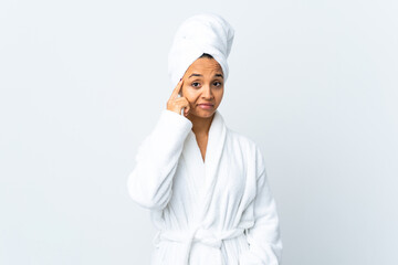 Young woman in bathrobe over isolated white background thinking an idea