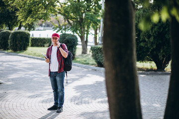 Young male student drinking coffee in park