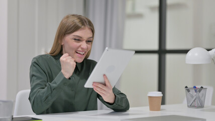 Successful Woman Celebrating on Tablet at Work 