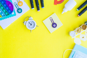 Close up of stationery and silicone toy popit. Flat lay composition. Yellow background. Space for...