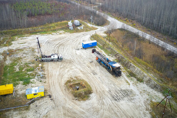 Repair work on the cluster site of oil wells. Geophysical studies in one of the wells. Shooting from a drone. - obrazy, fototapety, plakaty