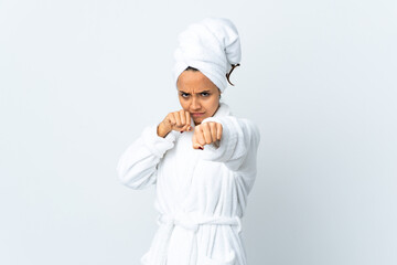 Young woman in bathrobe over isolated white background with fighting gesture