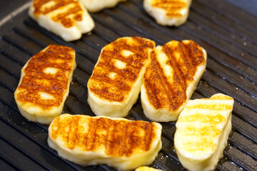 Frying cheese in a grill pan. Halloumi cheese has a high melting point, and therefore it can be fried or grilled.