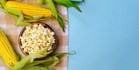 Fresh uncooked corncob, popcorn. Healthy summer food concept. Blue Background. Copyspace