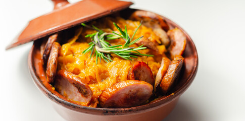 Traditional Polish dish called bigos made of sauerkraut, sausage and mushrooms, food served warm in a ceramic bowl