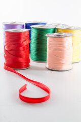 rolls with multi-colored ribbons for clothes on a white background