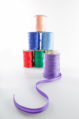 rolls with multi-colored decorative ribbons for clothes on a white background