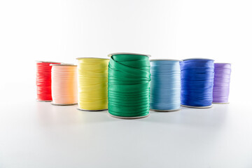 rolls with multi-colored decorative ribbons for clothes on a white background