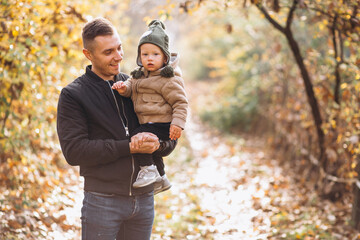 Naklejka na ściany i meble Father holding his son in park