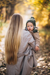 Young mother with her little daughter in an autumn park