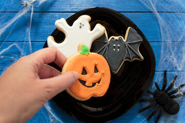 Top view of woman's hand holding halloween cookie