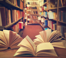 Open books on wooden table in library