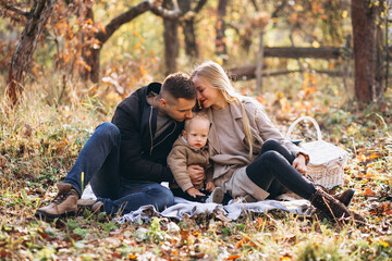 Fototapeta premium Family having small picnic with their son in autumn park