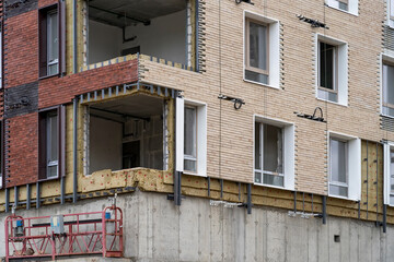 Facing building with ventilated facade. Modern facades of high-rise buildings. Construction of large residential complex. Monolithic concrete frame of apartment building under construction