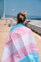 transsexual woman with trans flag, holding a transgender pride flag