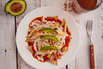 Chilaquiles rojos con pollo y aguacate comida tradicional mexicana en el desayuno o comida.