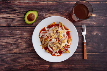 Chilaquiles rojos con pollo y aguacate comida tradicional mexicana en el desayuno o comida.