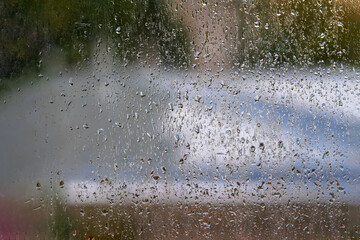 Rain drops on window glass, autumn evening. Natural background