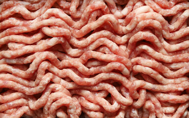 Raw minced beef and pork chopped in meat grinder, close-up red food backgrounds