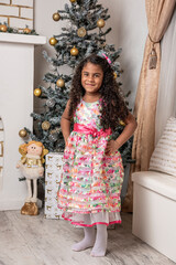 Hermosa niña afro caribeña disfrutando de la navidad con un árbol, adornos y regalos de fin de año