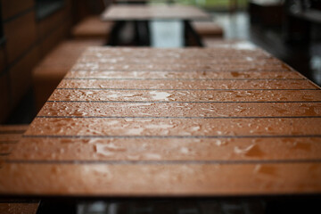Wet board. Water droplets on the surface. Details of the bench in rainy weather.