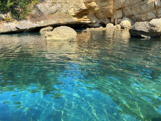Paradise sea lagoon with turquoise jade water at summer. Beautiful sea grotto ave in coastal rocks. Idyllic seascape. Crystal clear shiny water of Mediterranean sea.