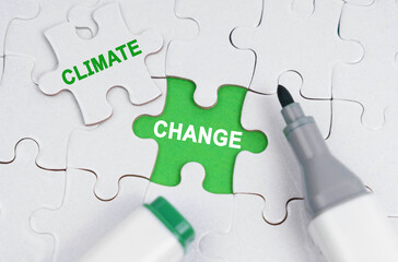 White puzzles lie on a green background, in place of an open puzzle it is written - Climate Change