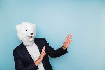 Man with polar bear mask pointing to the side.