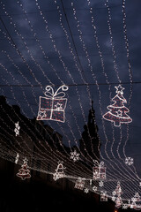 Occasional glowing Christmas and New Year decorations hang in the square, shot from the bottom at night