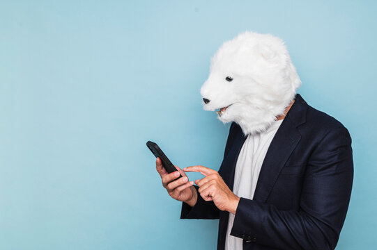 Man with polar bear mask using a smart phone.