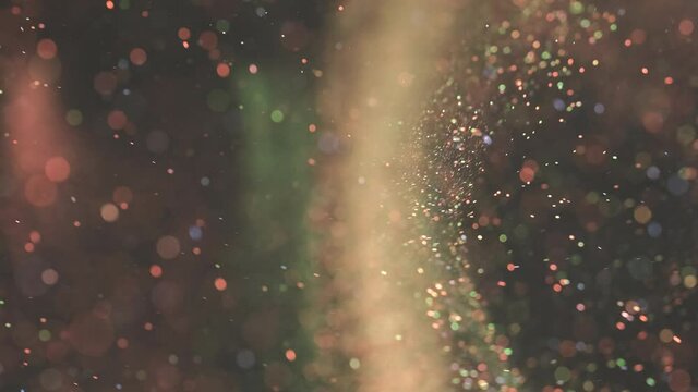The colorful particles floating on the dark background. slow motion