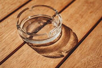 round glass ashtray in sunny natural light by the window on a table in a cafe