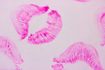 Beautiful shape pink female lip prints on white paper background top view. Kisses flat lay....