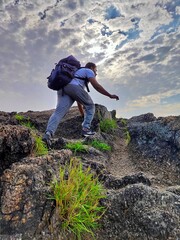 The boy try to climb a mountain and he reached his goal and after he focuses on his next goal. 