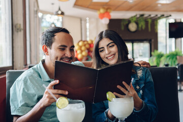 Latin couple reading the restaurant menu 