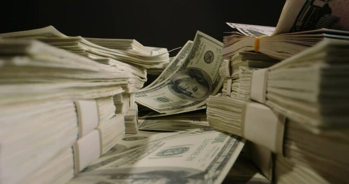 Packs of cash lying on table. 100 US dollars bills chaotically spread around the table. Cash flow, banking, business and financing concept 4k footage