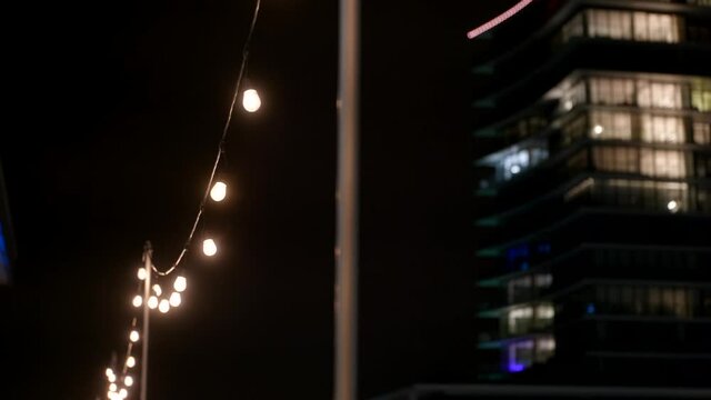 Soft yellow bulbs hanging in the rain night hotel background
