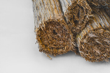 Straw rope dry reed natural material is stored in rolls on a white background - obrazy, fototapety, plakaty