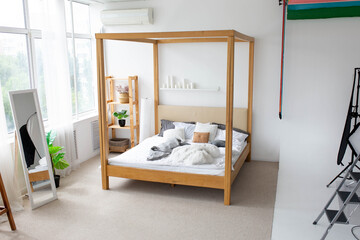 a wooden double bed in a large white room. interior photo zone in a photo studio
