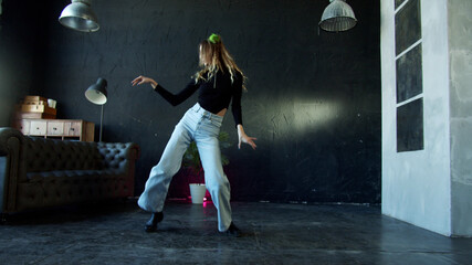 Girl is dancing and making fun poses in a dance hall 
