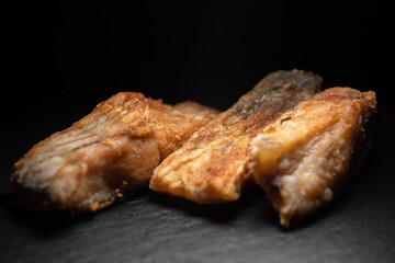 Three fried carp fish on a black background