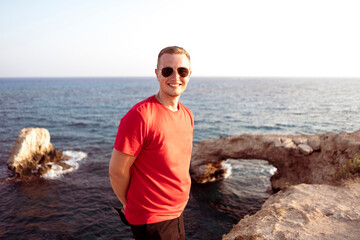 a young man standing on the sea coast, portrait on summer day