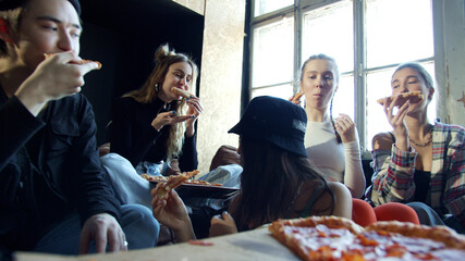 Closeup video of modern hipsters eating pizza in a dance studio