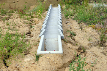 A system of concrete modules for draining excess water from the road surface.  Construction of the highway.