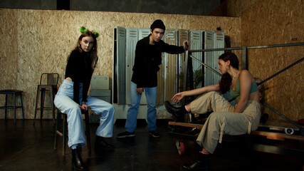 Obraz na płótnie Canvas Young modern persons pose isolated in a sports locker room