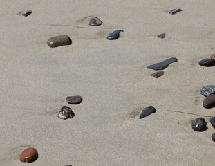 pebbles on the beach, smooth polished multicolored stones washed ashore on the beach, background, textures