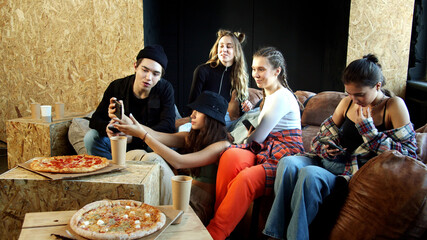 A group of dancers does not pay attention to the pizza but taking selfie
